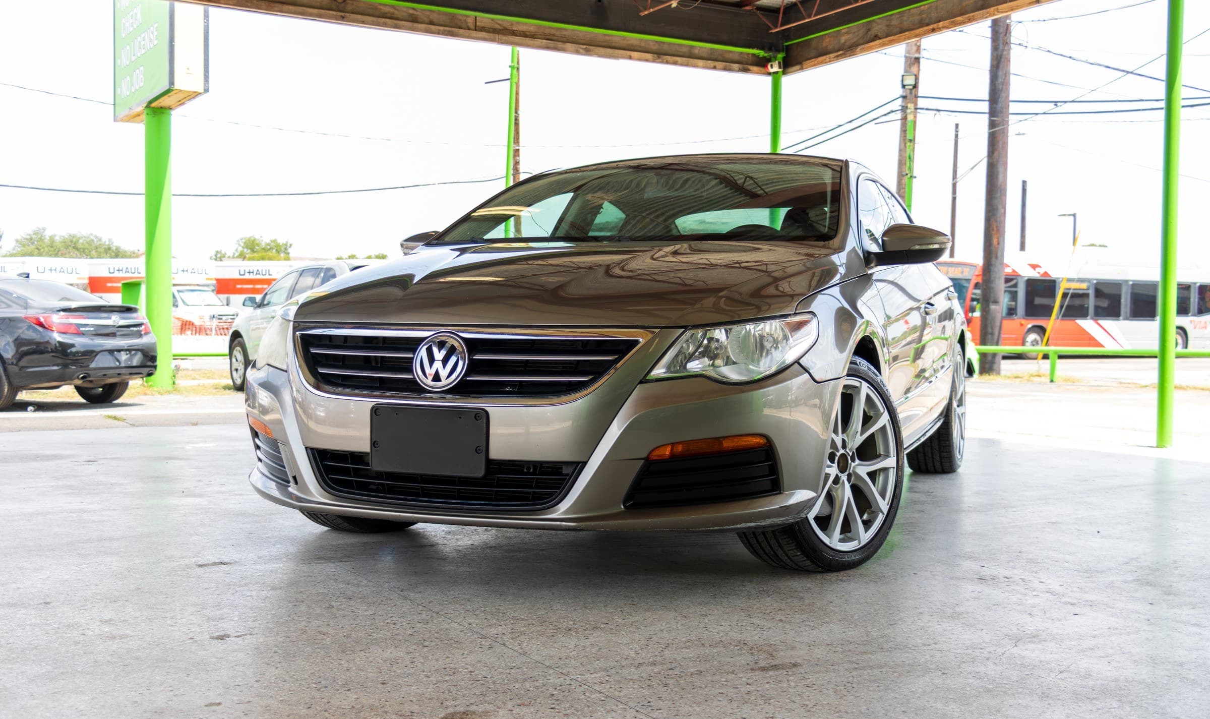 Brown metallic 2012 Volkswagen CC Sport seen head-on from a low front angle, showing the chrome grille bars and VW badge.