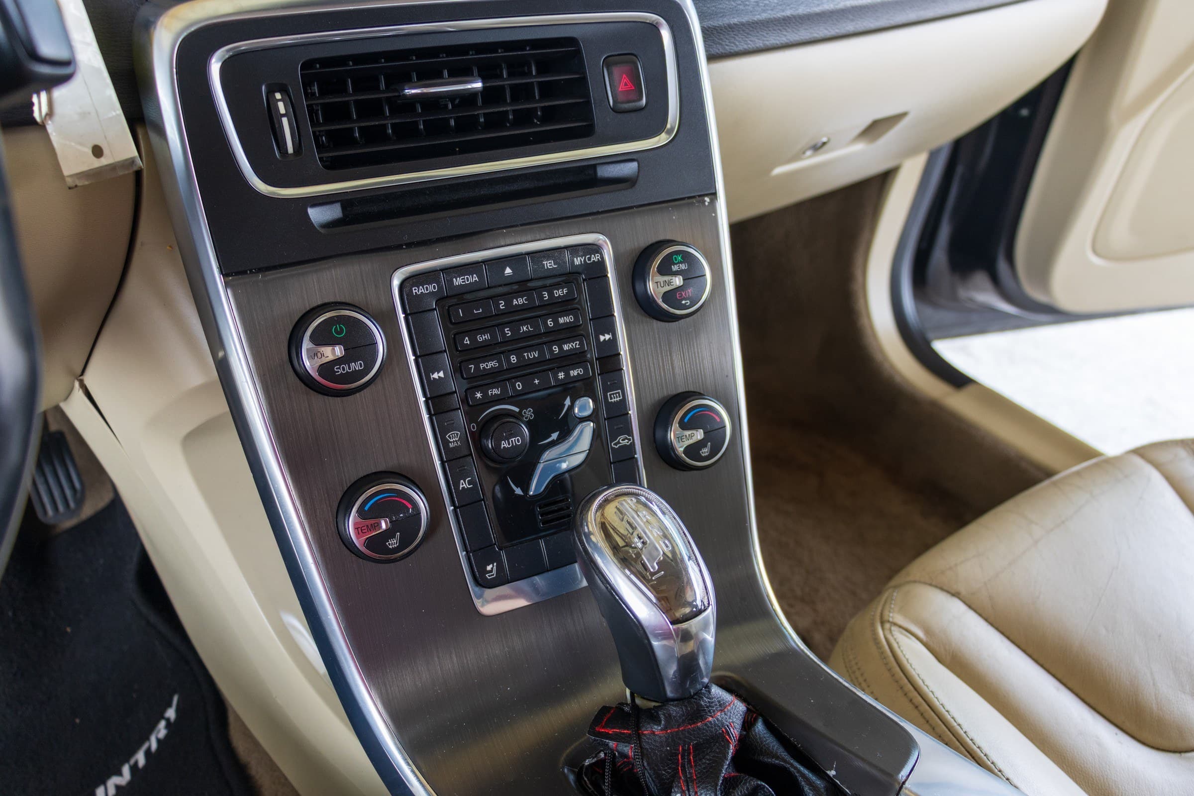 Close-up of the S60's center console: audio keypad, climate dials with heated-seat controls, and the automatic gear selector.
