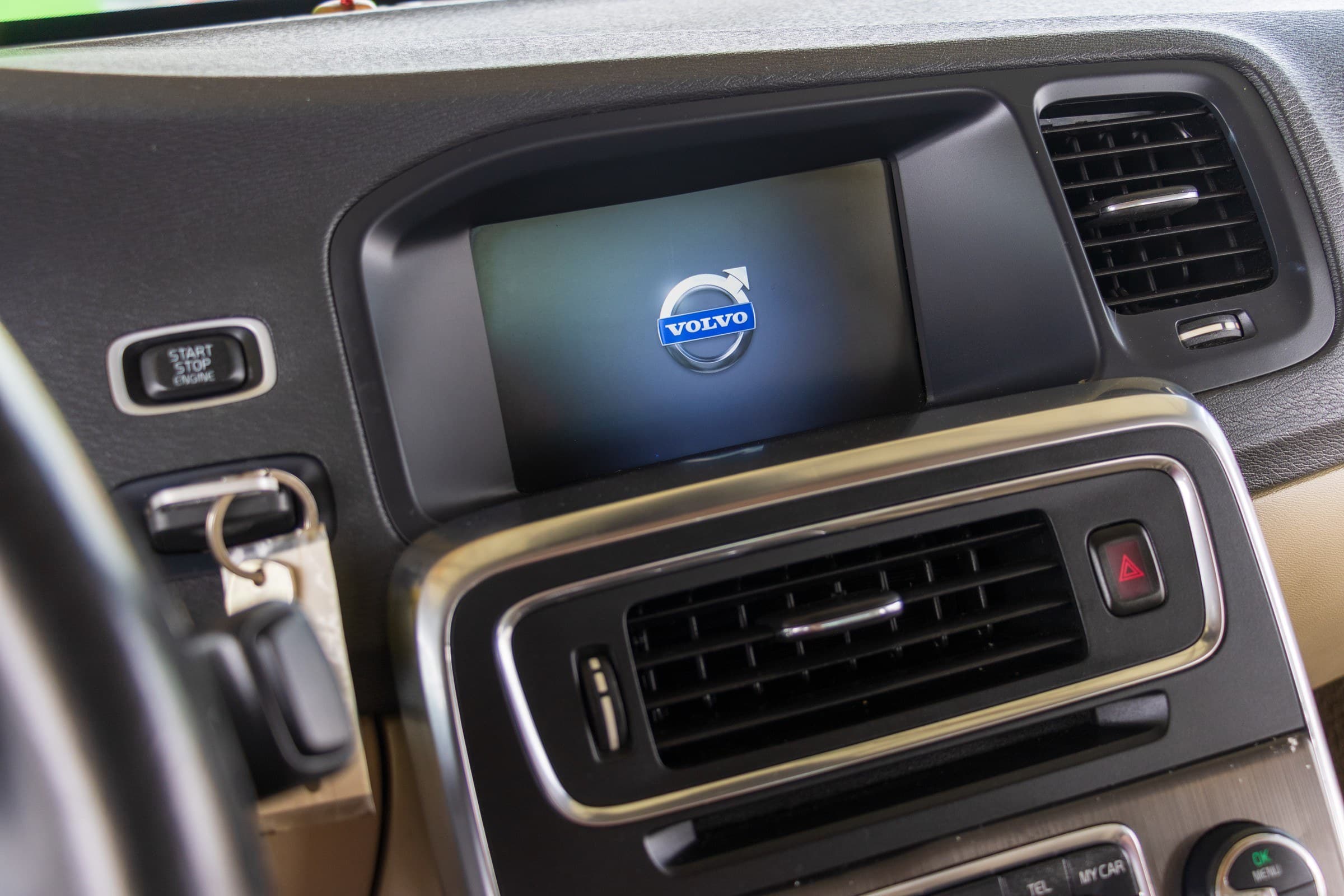 The S60's center stack, showing the Sensus display screen and the keyless start-stop engine button.