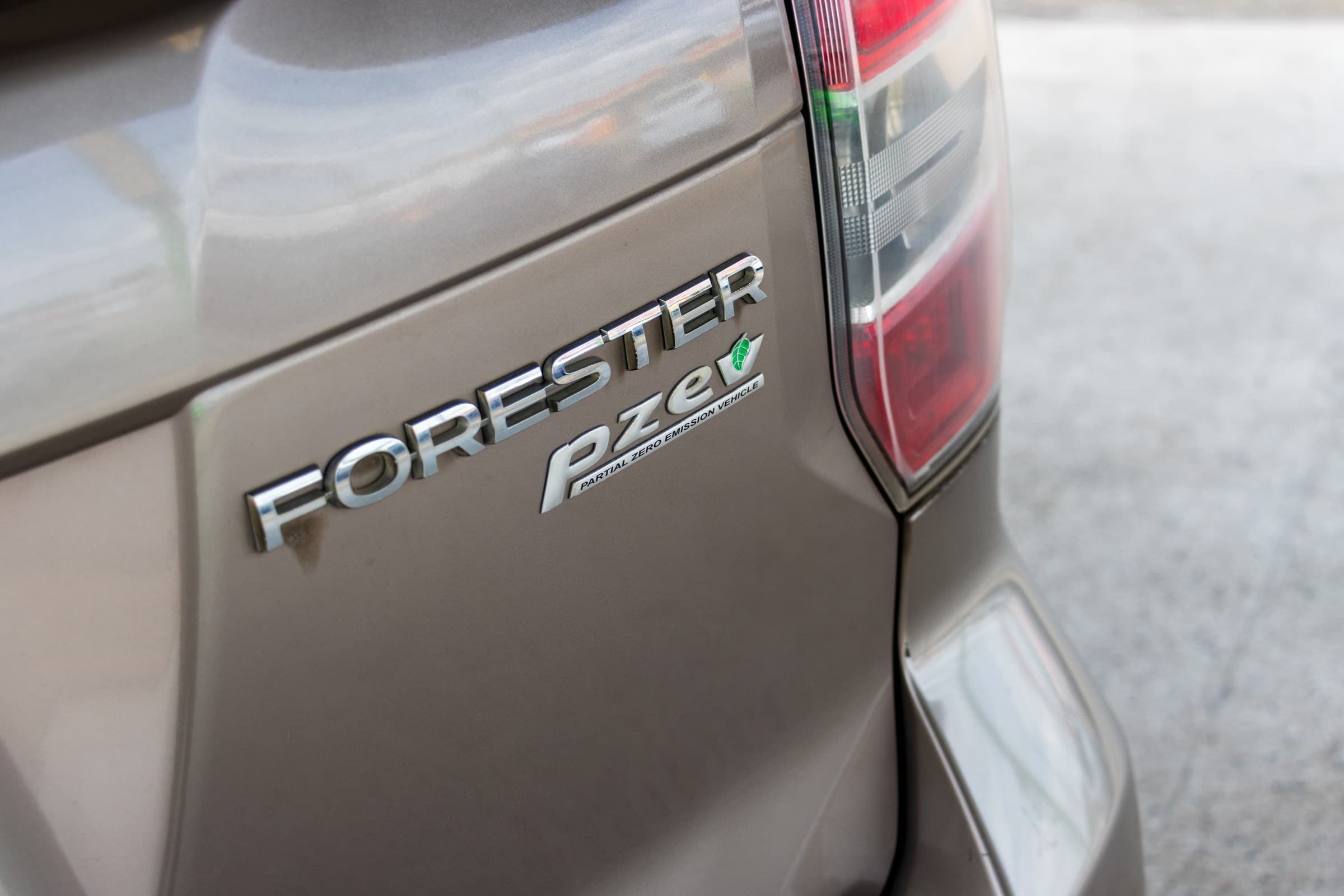 Close-up of the chrome Forester and PZEV partial zero emission vehicle badges on the tailgate.